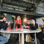 portrait of young business woman in red shirt at modern startup office interior, team in meeting